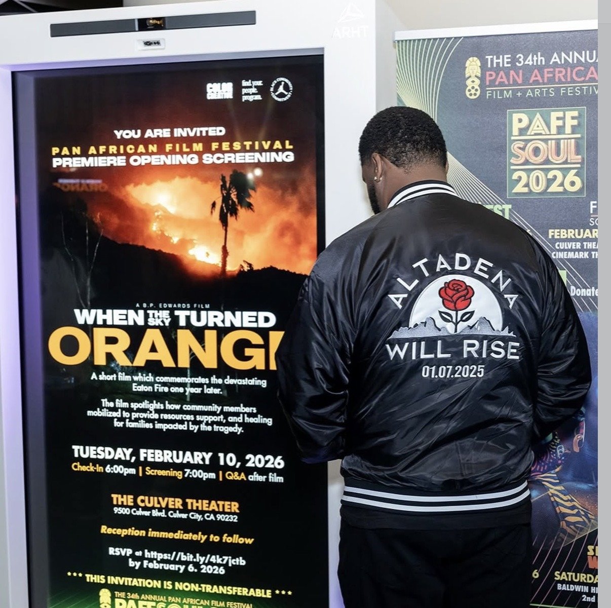 A man in a black jacket with a red rose logo and the words "Altadena Will Rise" stands in front of a poster advertising the Pan African Film Festival premiere screening of "When the Sky Turned Orange" on February 10, 2026, at The Culver Theater in Culver City, California.