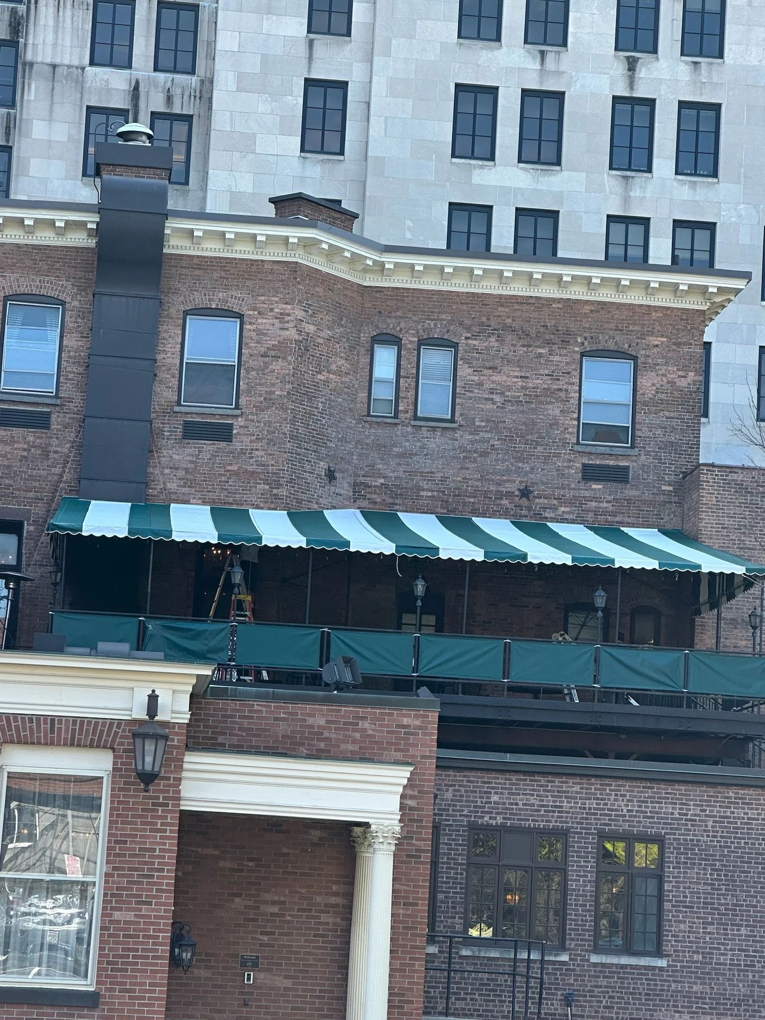 Green and White stripped Stationary awning at Fort Orange Club in Albany, NY. Setup by Whalen Tents