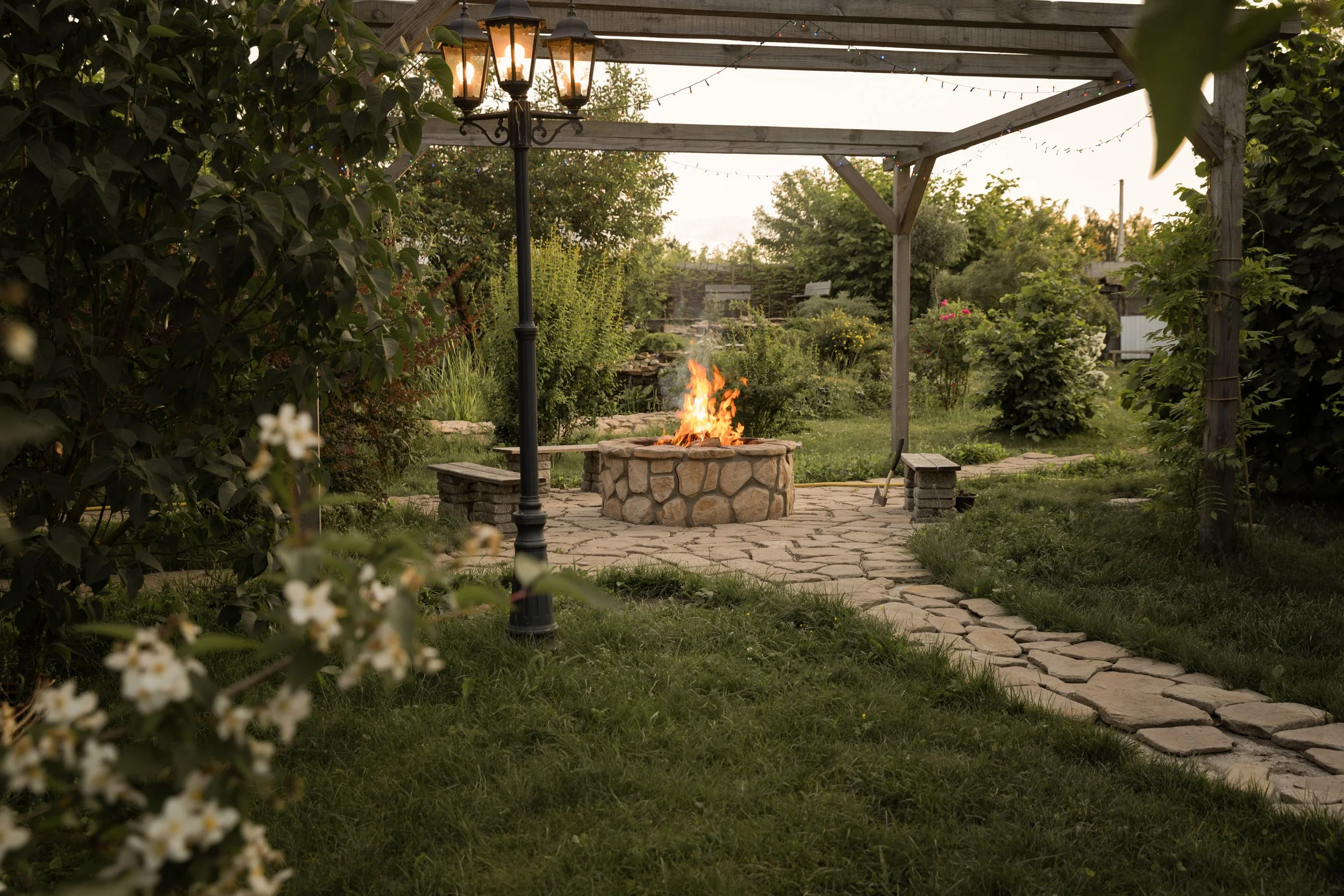A backyard pergola with fire pit seating area and landscape design in East Greenwich, RI