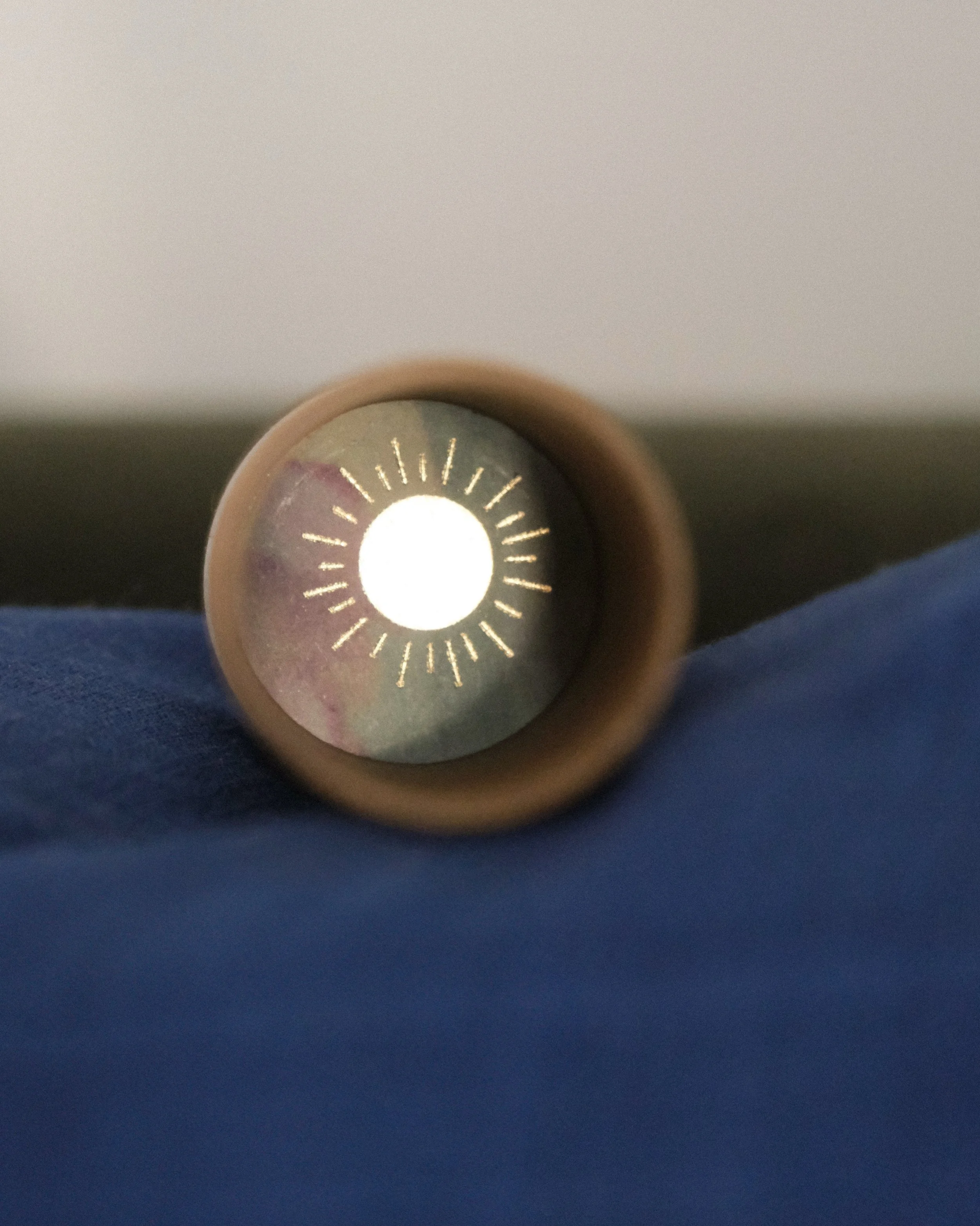 Close-up view of a metallic tube or pipe, positioned horizontally, with the camera looking through its circular opening, revealing a decorative pattern inside.