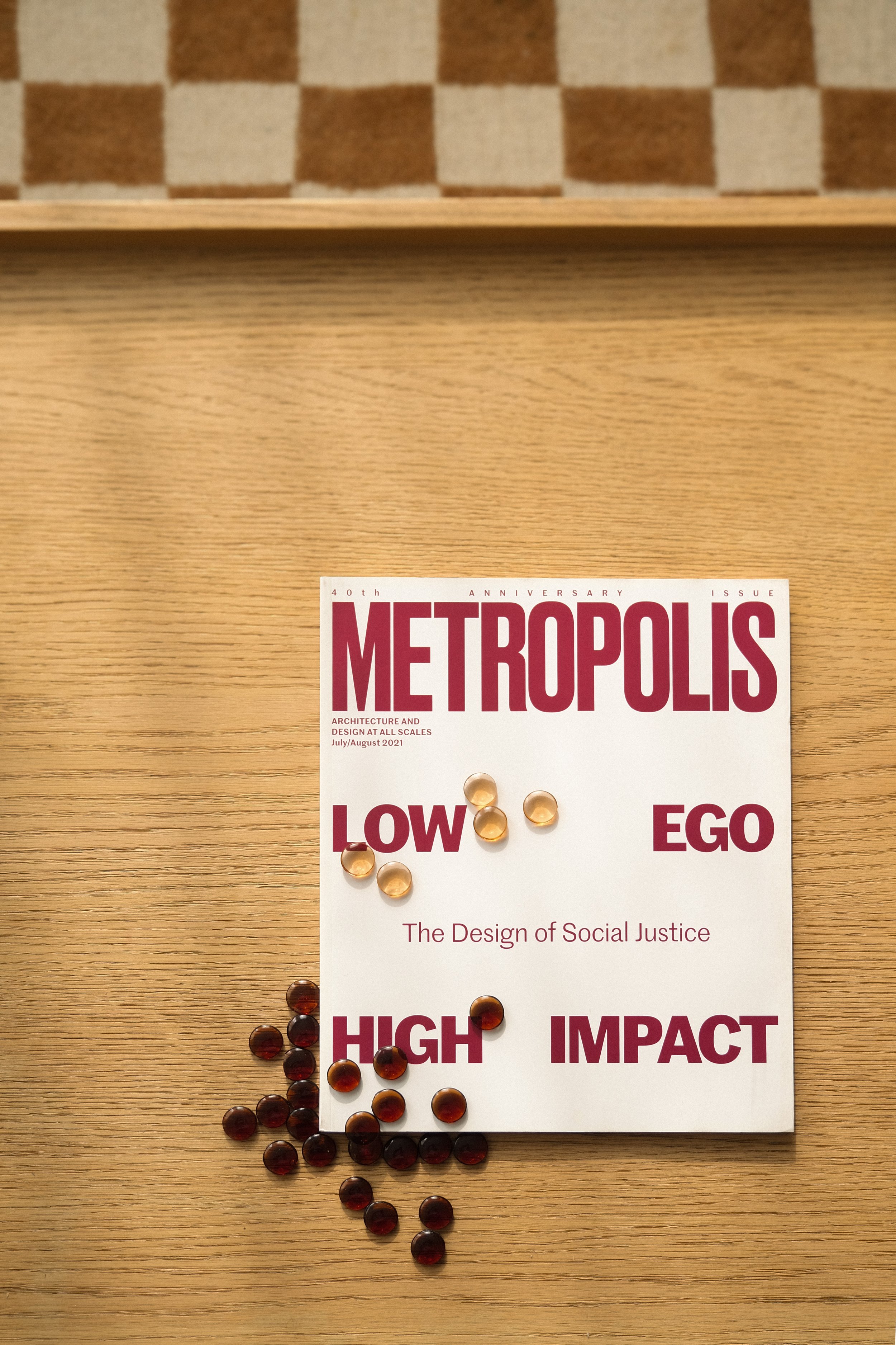 A magazine titled 'Metropolis' with pills scattered on and around it, on a wooden surface.