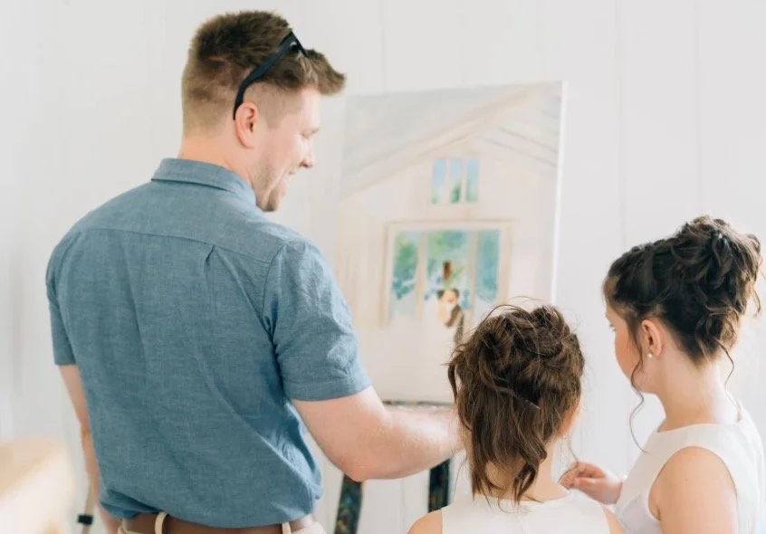 Columbus ohio live wedding painter smiles while letting flower girls add to the live wedding painting.