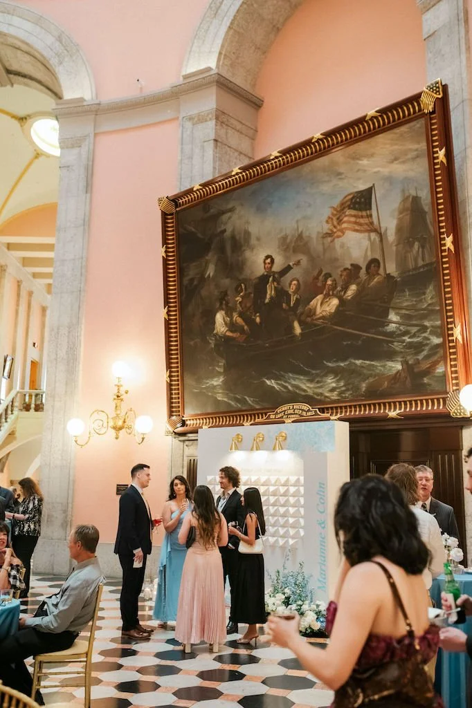 A group of people gathering under a painting at the Ohio Statehouse Wedding