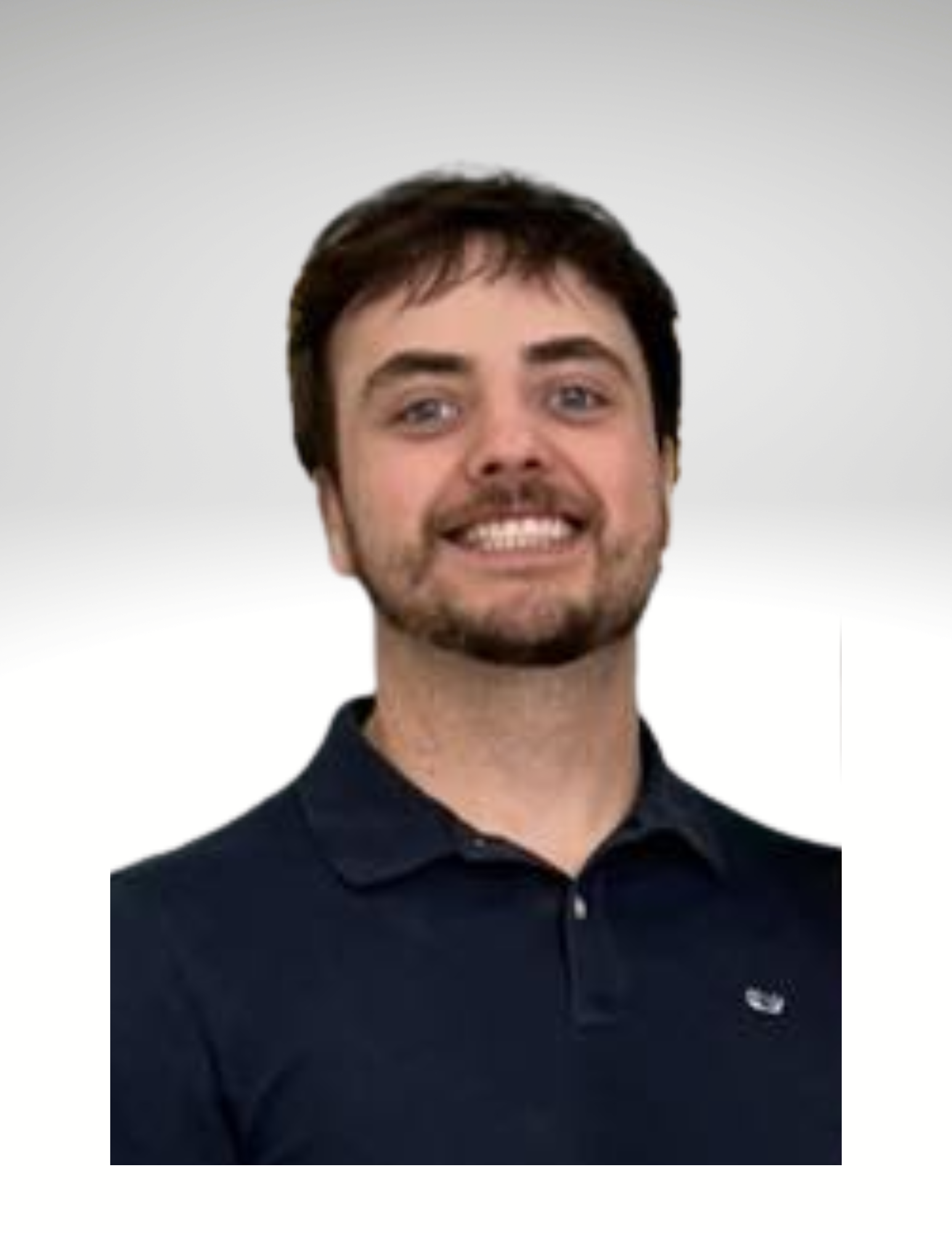 Young man with short dark hair, facial hair, smiling, wearing a black polo shirt.