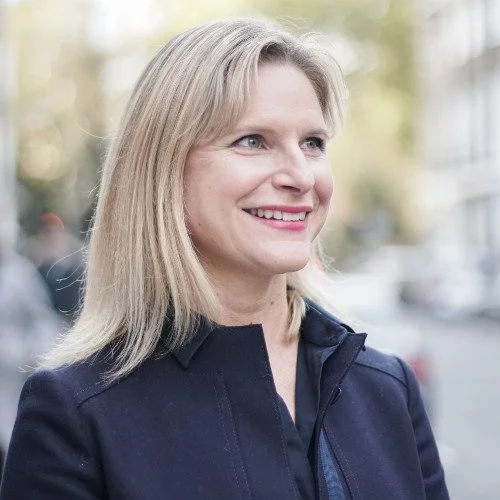 Imke, flüf's financial advisor, smiling outdoors.