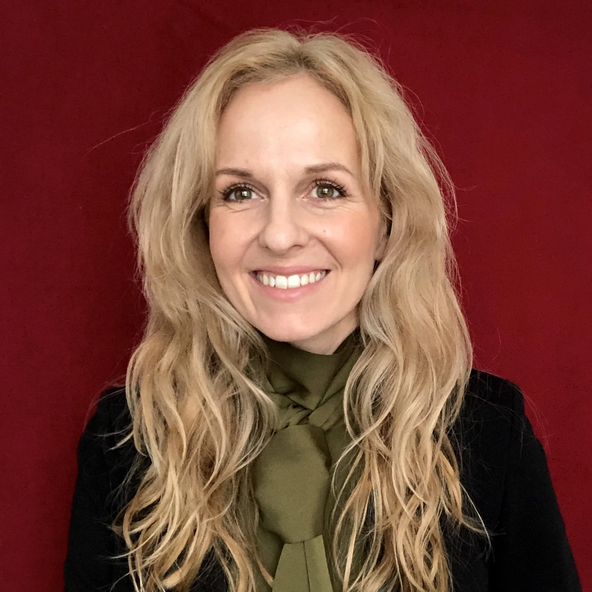 Maria Brendes, co-founder of flüf, smiling against a red background.