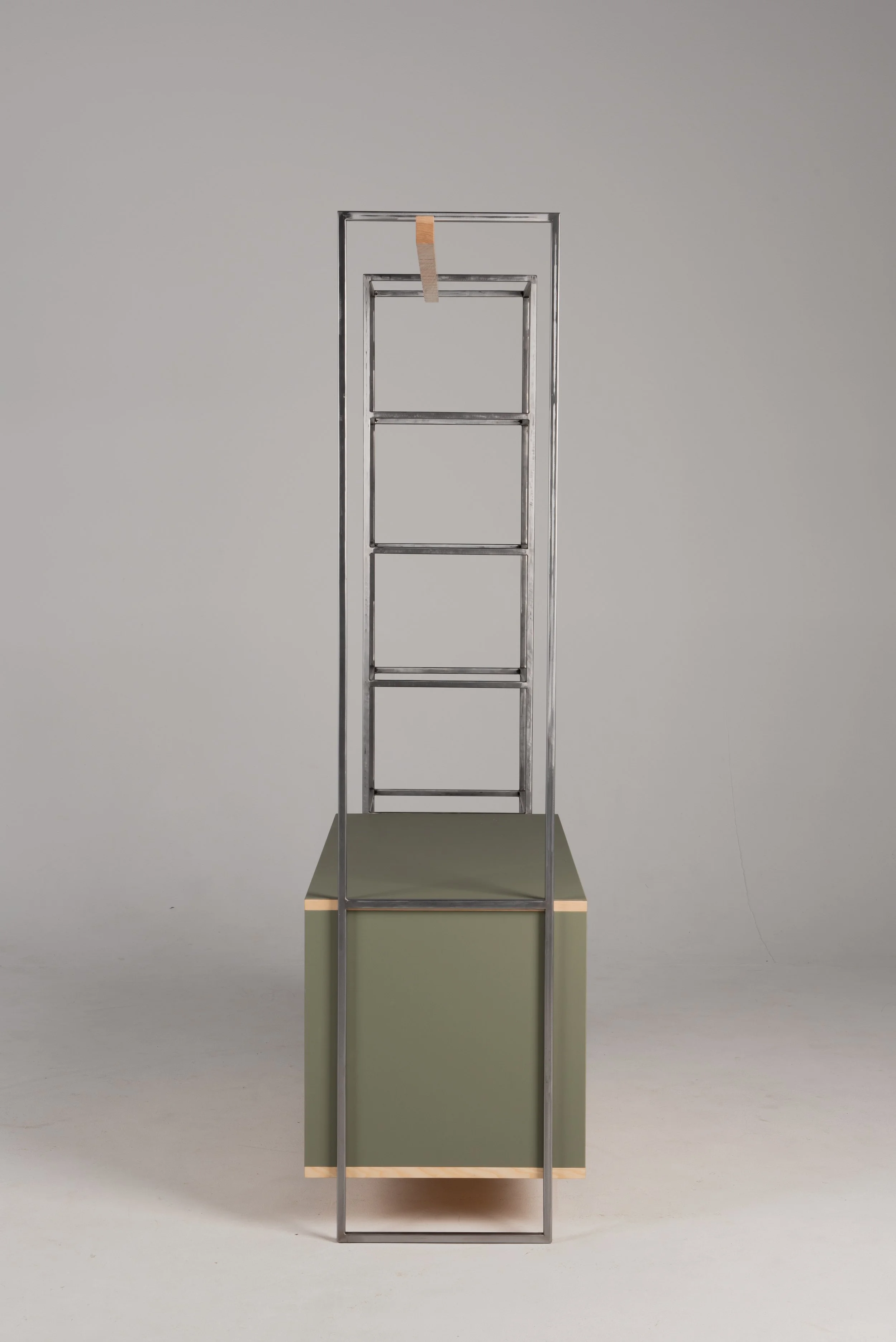 Ein moderner, minimalistischer Metall-Standregal mit fünf offenen Fächern, das auf einer quadratischen, grünen Basis steht.