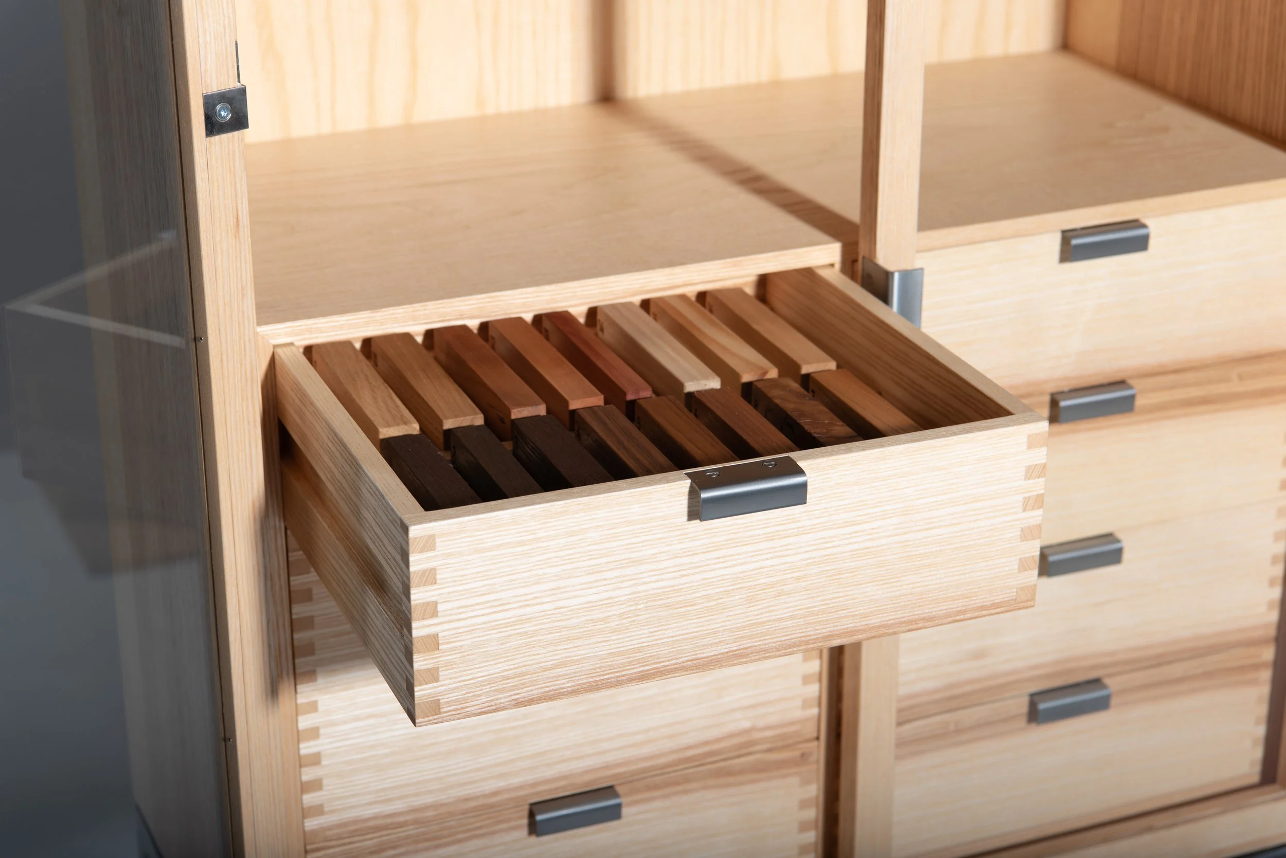 Holzschublade mit verschiedenen Holzproben in einem Holzschrank