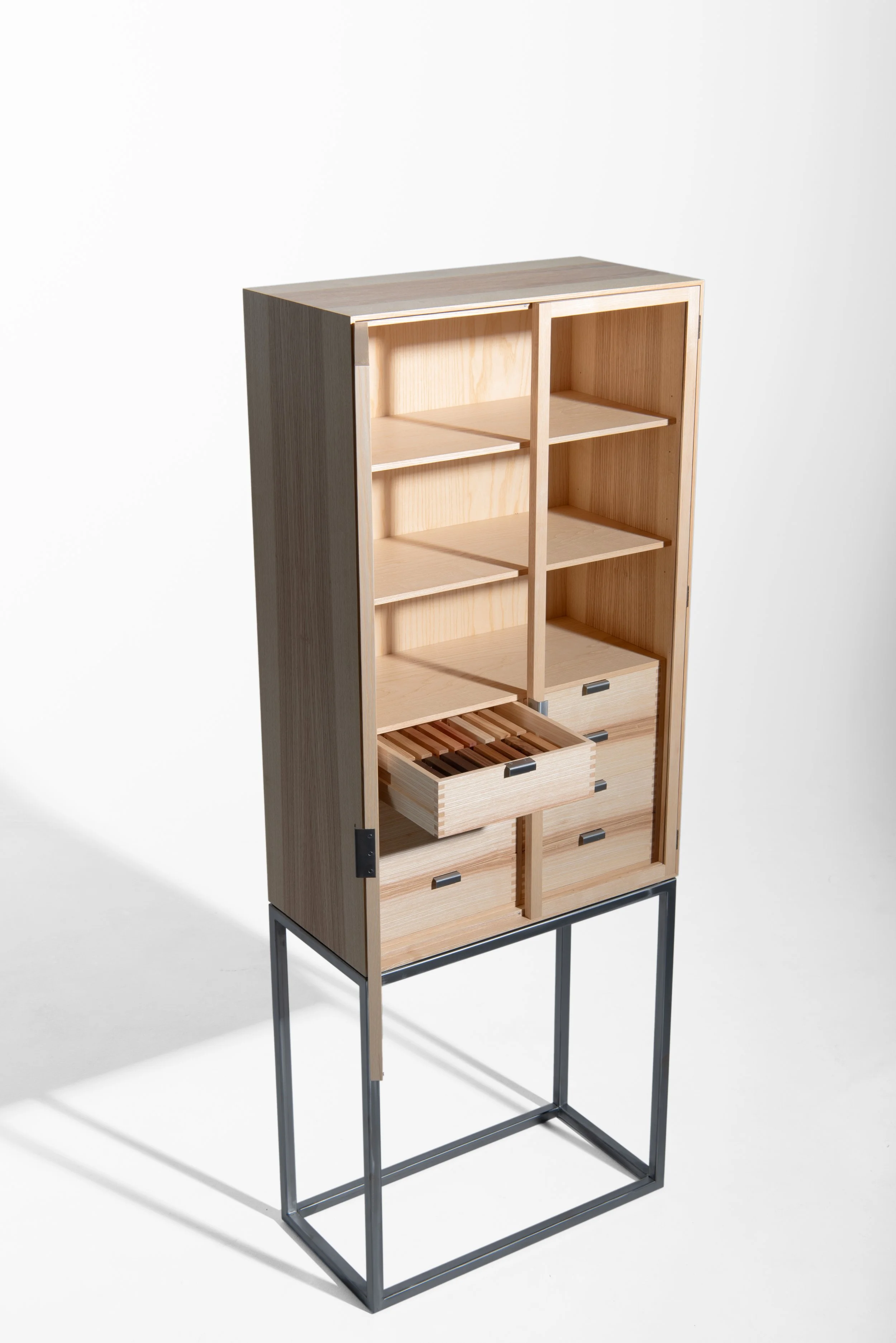 Ein hölzernes Möbelstück mit mehreren Regalfächern und Schubladen, auf einem schwarzen Metallgestell.