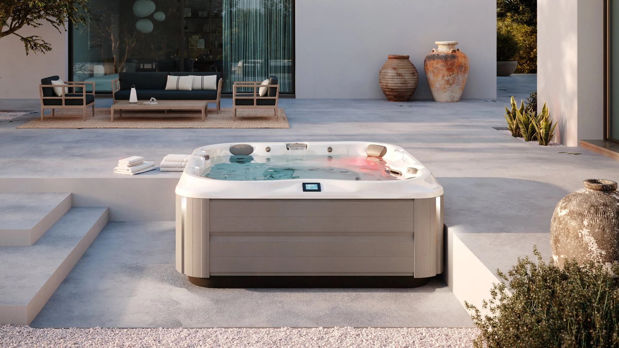 Outdoor patio with a hot tub in the foreground, sitting area with black and wooden furniture, decorative pottery, and potted plants.