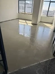 Empty room with large windows, polished floor, and white walls.