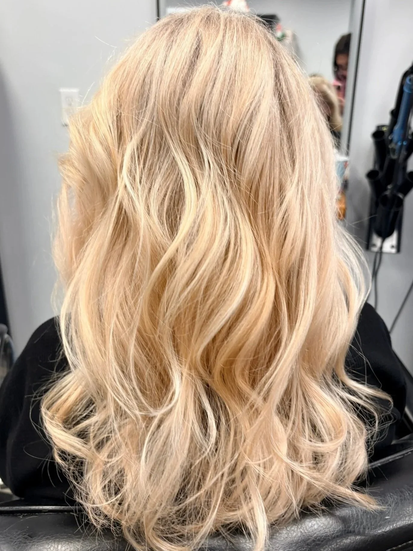 Close-up of water with ripples on a sandy surface, showing light reflections and small stones beneath the water.