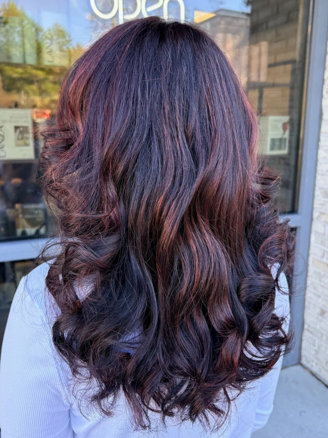 Modern house with a swimming pool, outdoor lounge chairs, desert landscaping, and mountains in the background during sunset.