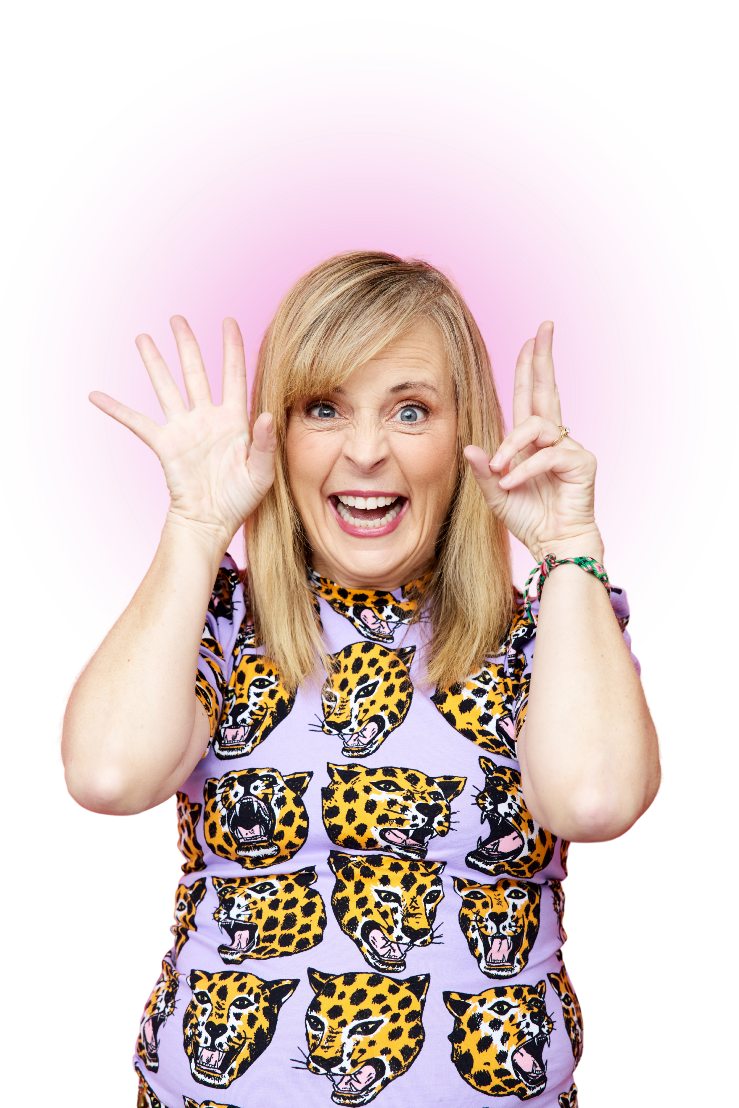A woman with blonde hair and bright blue eyes smiling widely, making a peace sign with her fingers, dressed in a purple shirt with a jaguar pattern, standing in front of a digitally added pink and purple circular background.