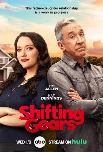 A promotional poster features a young woman with dark hair and makeup standing next to an older man with gray hair. Both are posing with serious expressions. The background shows a suburban neighborhood scenery with a cloudy sky. Text at the top stat