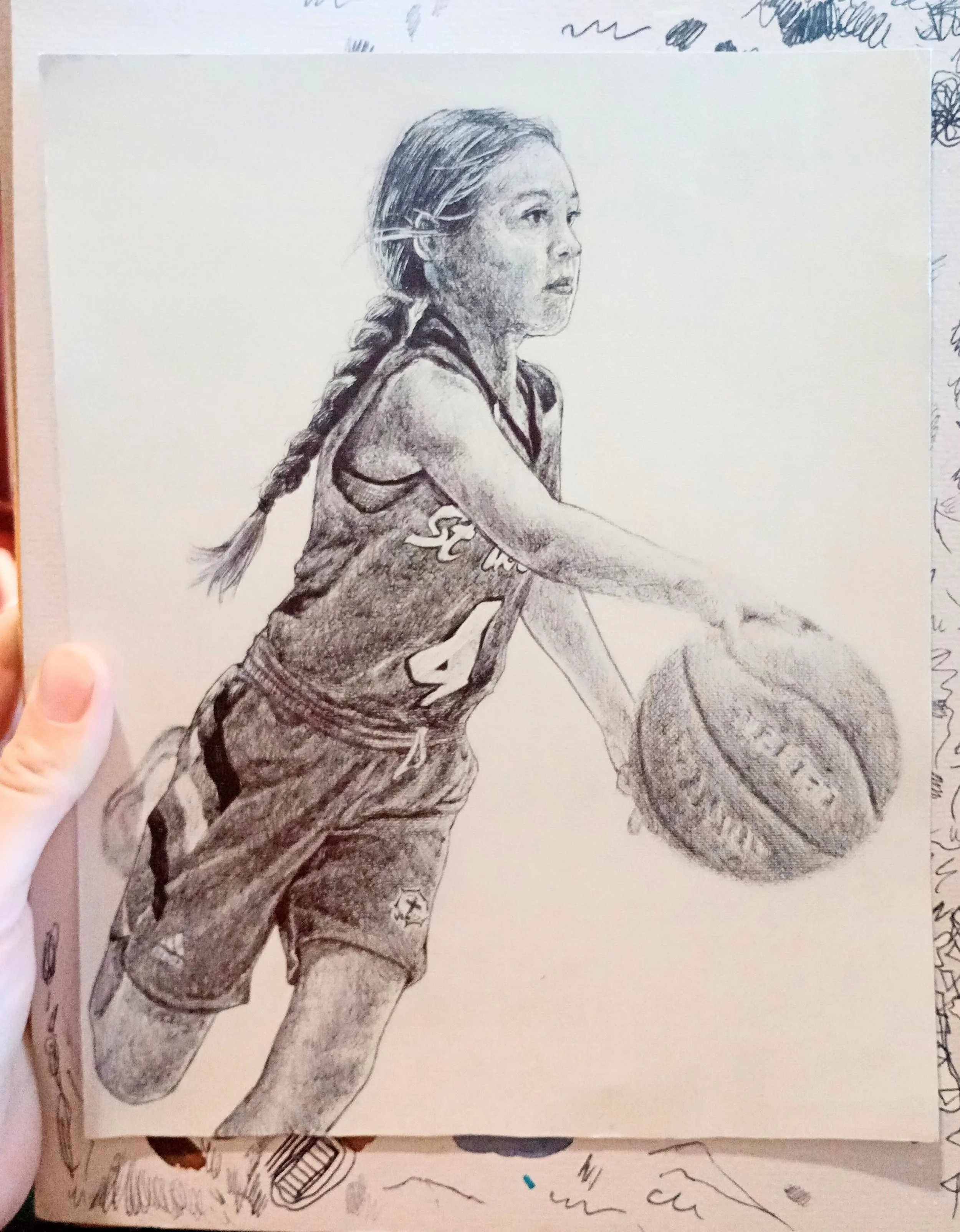 A detailed black and white pencil drawing of a female athlete with long hair tied in a braid, wearing a sports jersey with a number 24. She is in a side profile, appearing to be running or stretching, with a serious and focused expression.
