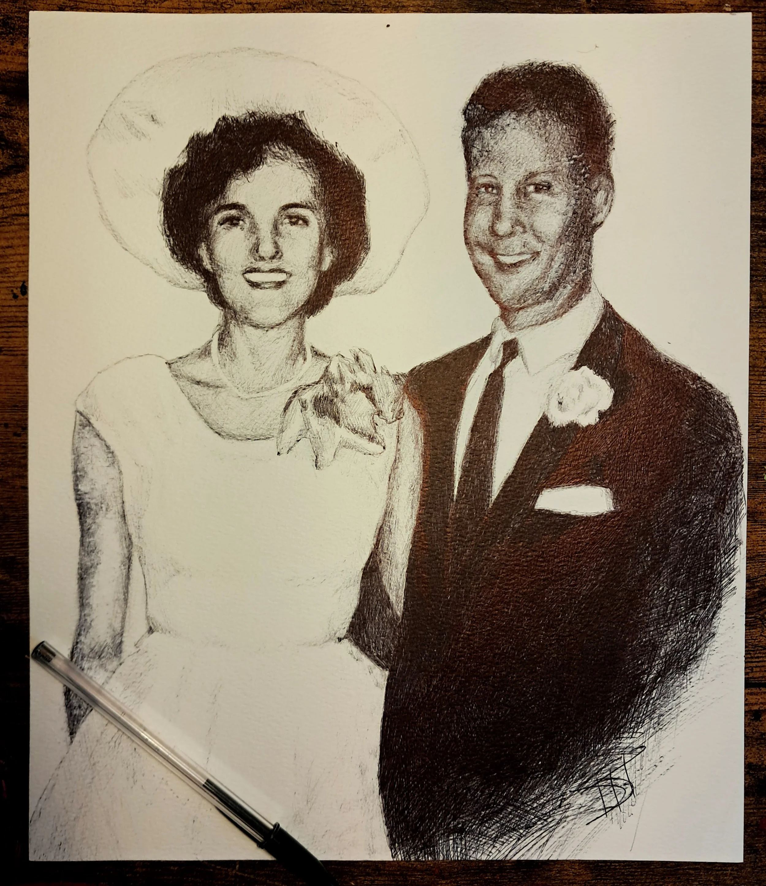 A partially finished realistic pen sketch of a smiling man in a tuxedo and a woman wearing a large hat, with a dog in the woman's hands. An ink pen is placed on the paper.