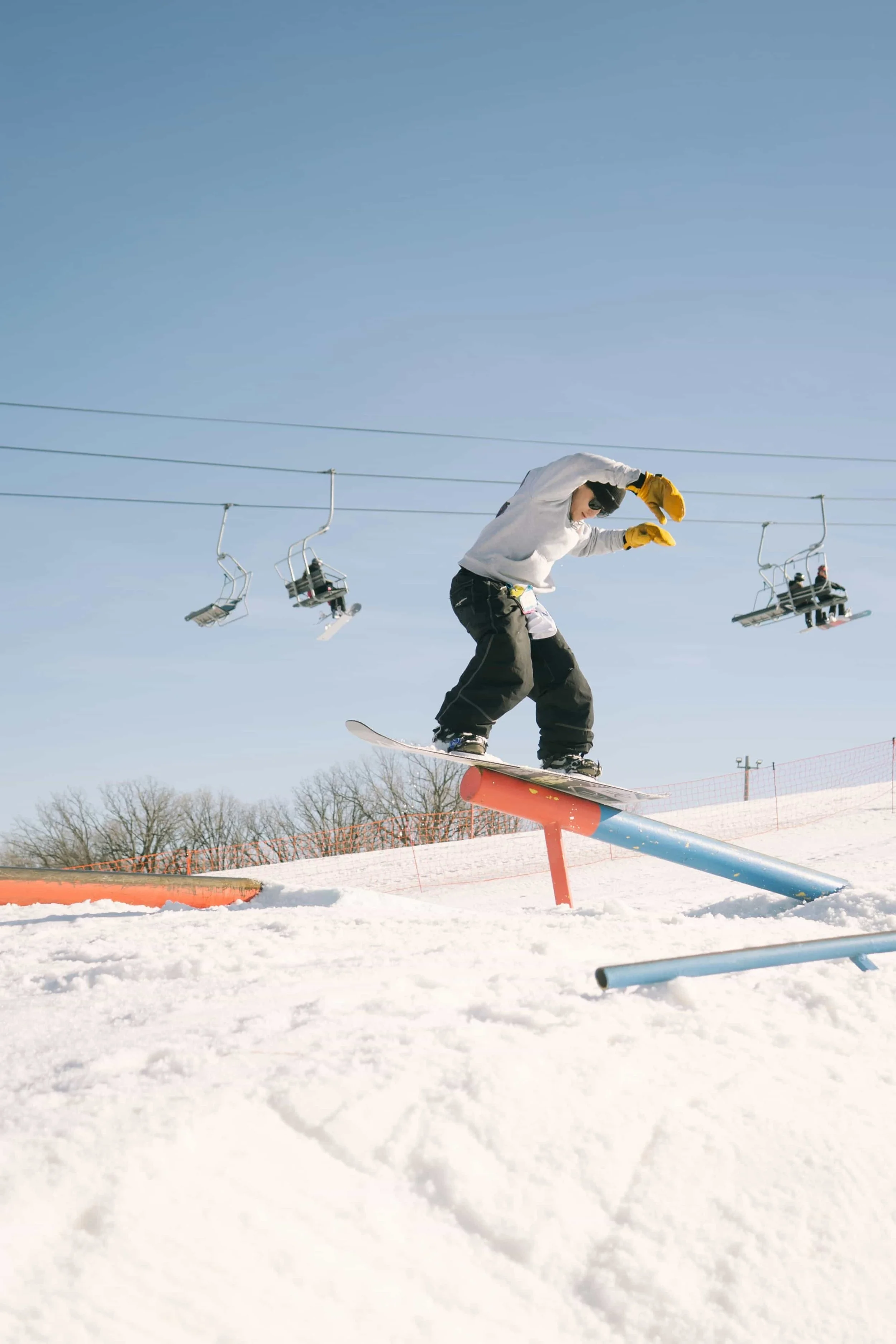 Snowboarder sliding on a rail in a freestyle terrain park