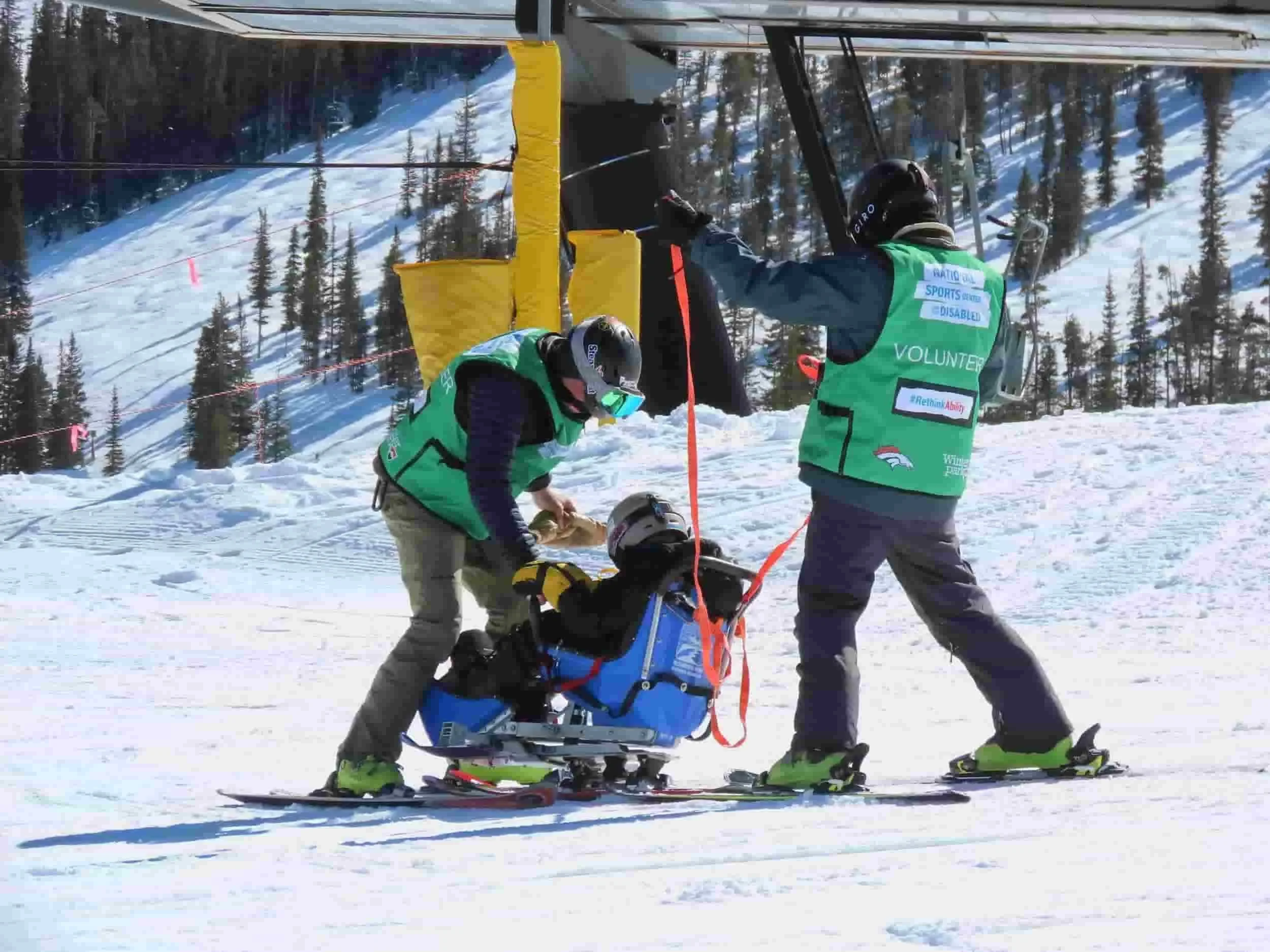 Differently abled skier with volunteers
