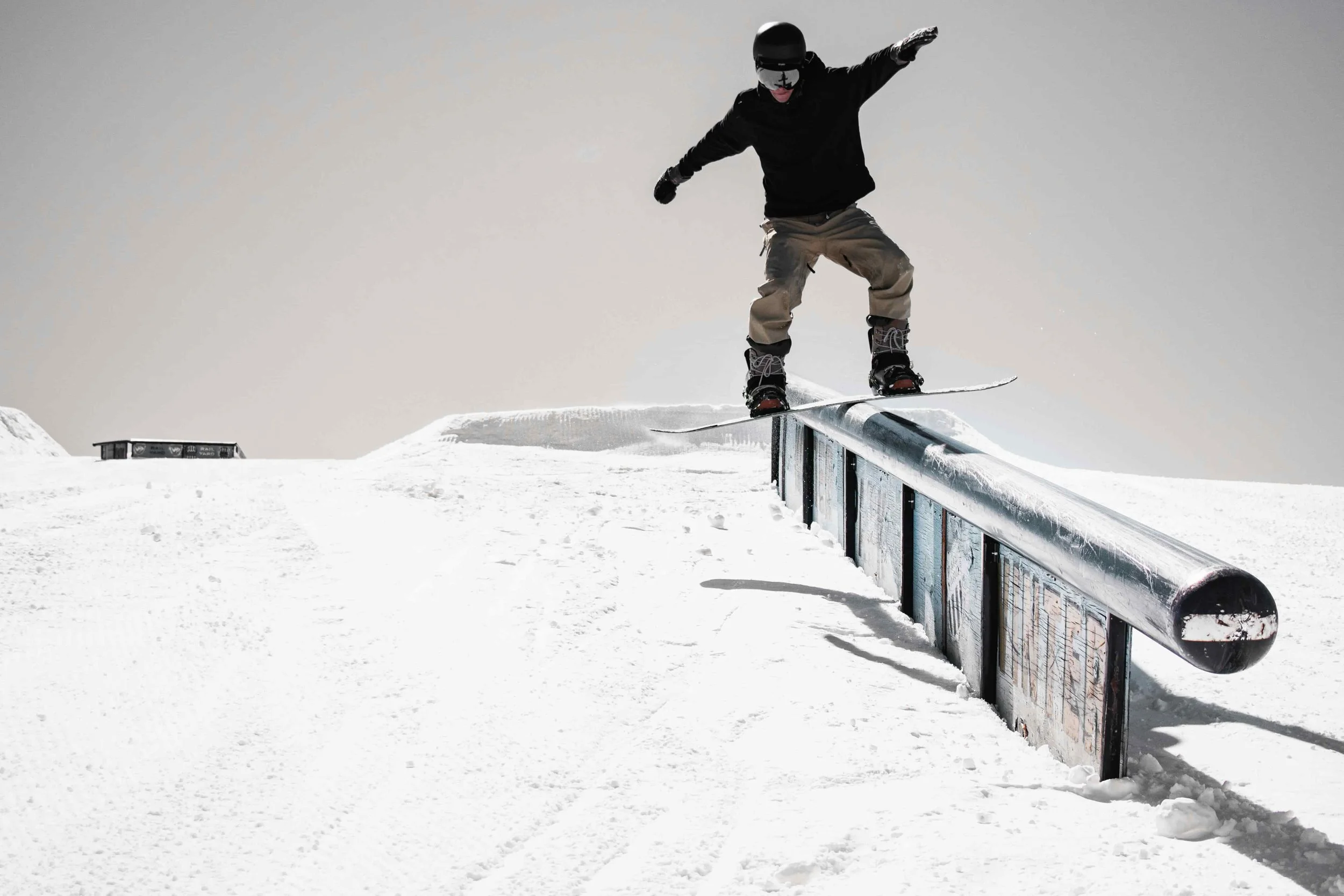 Snowboarder sliding a rail in terrain park