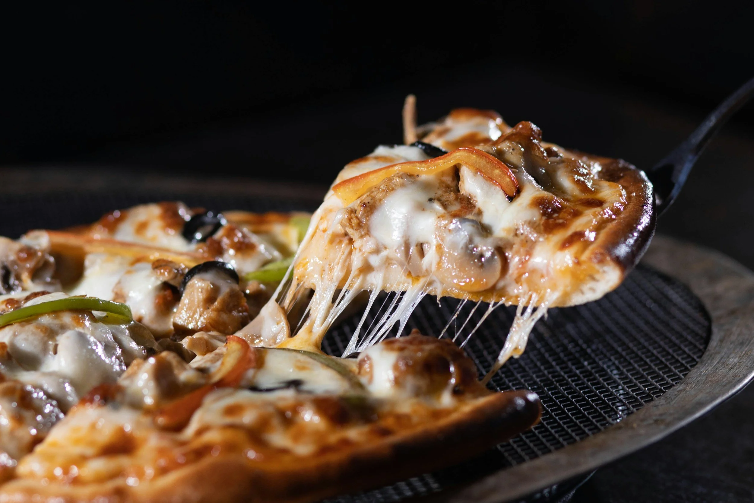 A slice of fresh pizza being served