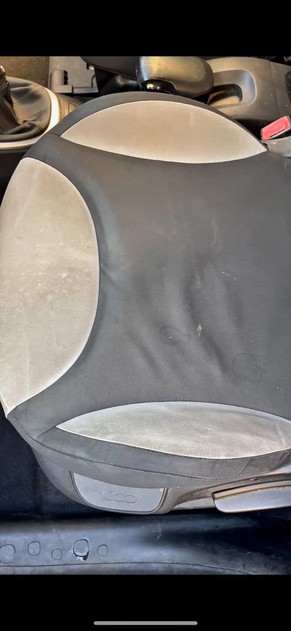 Sedile del veicolo con tessuto in due colori, sovrapposto a parte del cruscotto e del tunnel centrale.