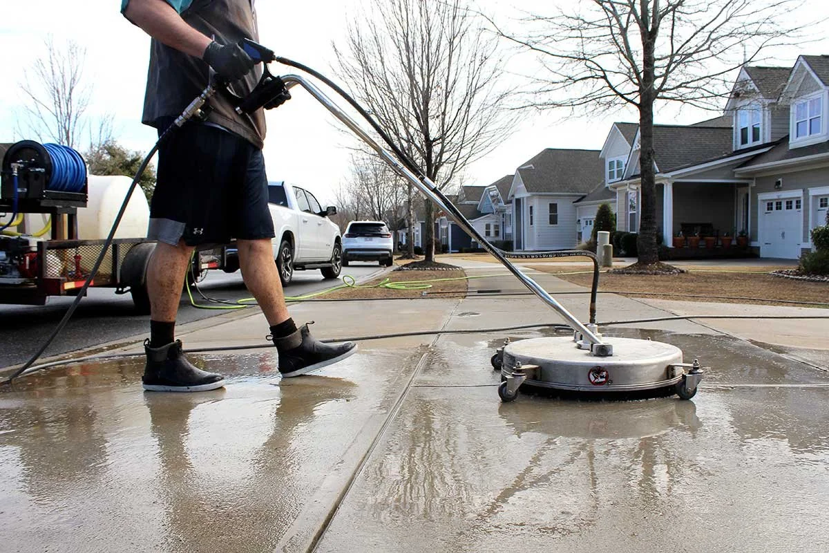 Professional pressure washing driveway surface.