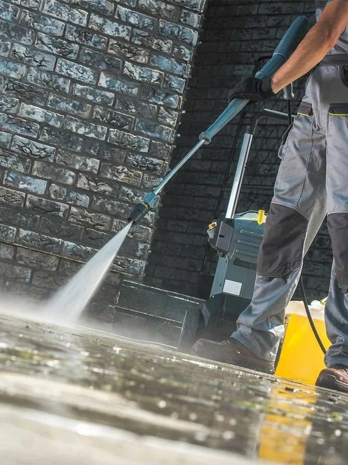 Professional pressure washing a patio area at neighborhood residence.