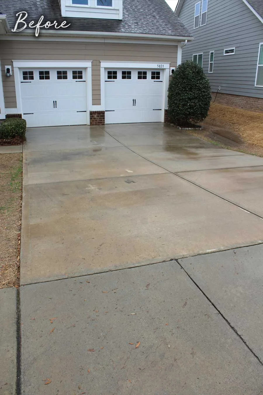 Driveway in residential neighborhood in Waxhaw, NC with dirt and stains.
