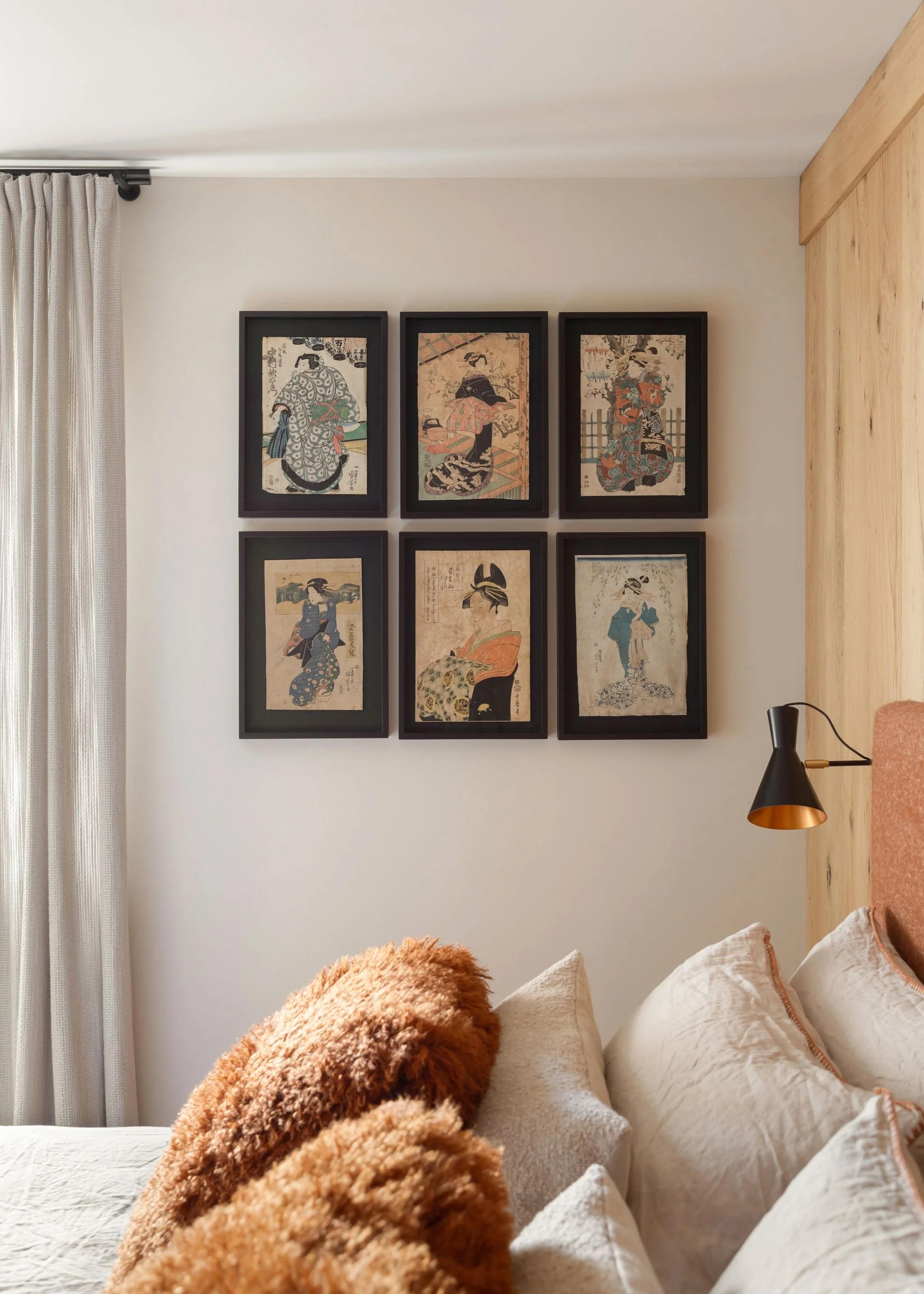 Parete con sei stampe di arte giapponese in cornici nere, arricchisce una stanza con letto e lampada da parete