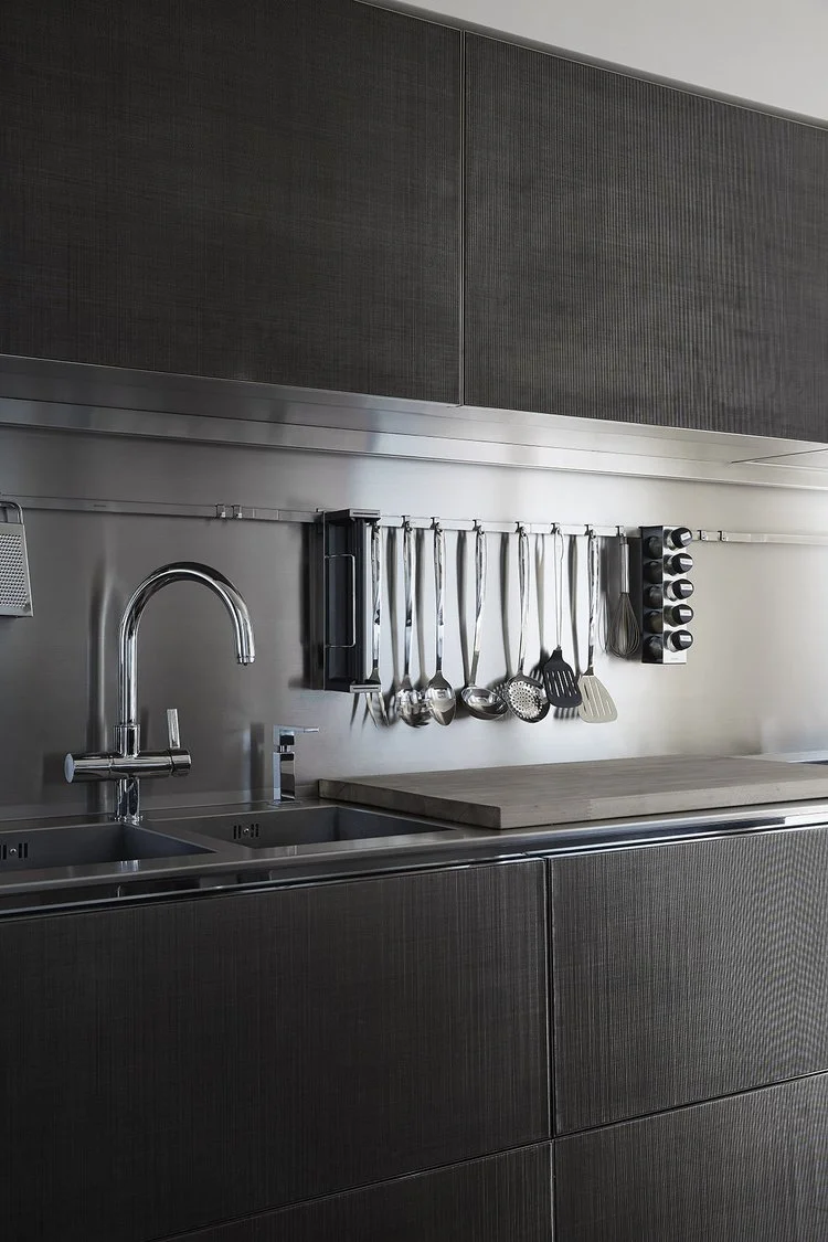 Cucina moderna con lavabo, rubinetto, utensili da cucina e spezie su parete