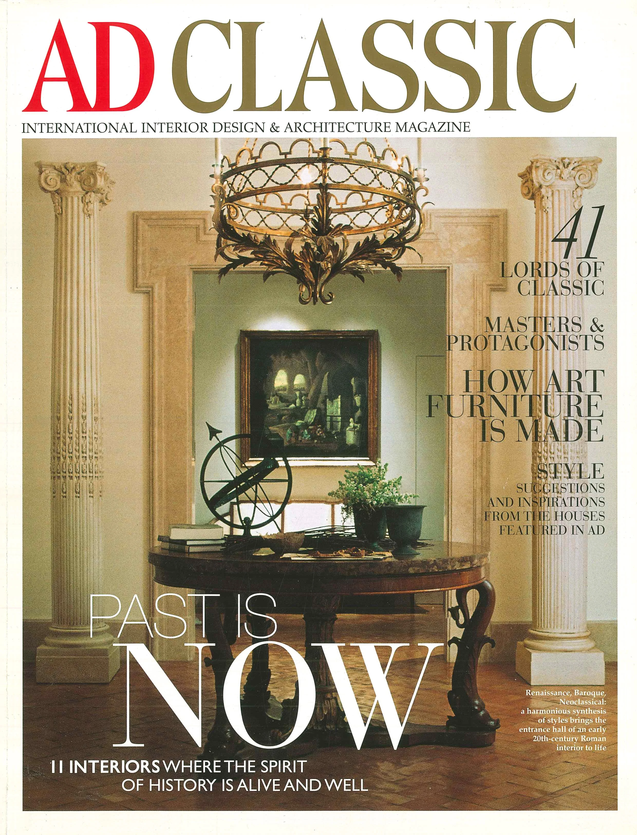 Copertina di una rivista di interior design con un interno classico, un tavolo in legno scuro, un chandelier antico e colonne decorate, con alcuni oggetti decorativi e un quadro alle pareti.