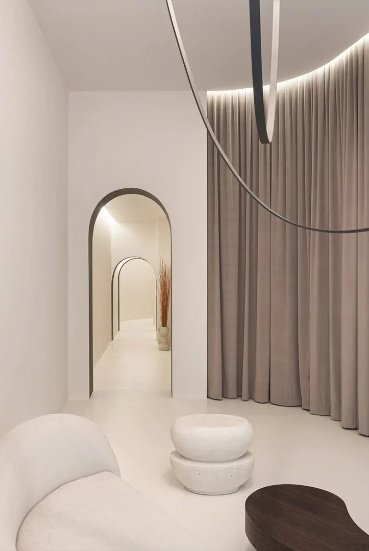 Interno di una stanza moderna con pareti bianche, tende beige, argo scuro e decorazioni minimaliste.