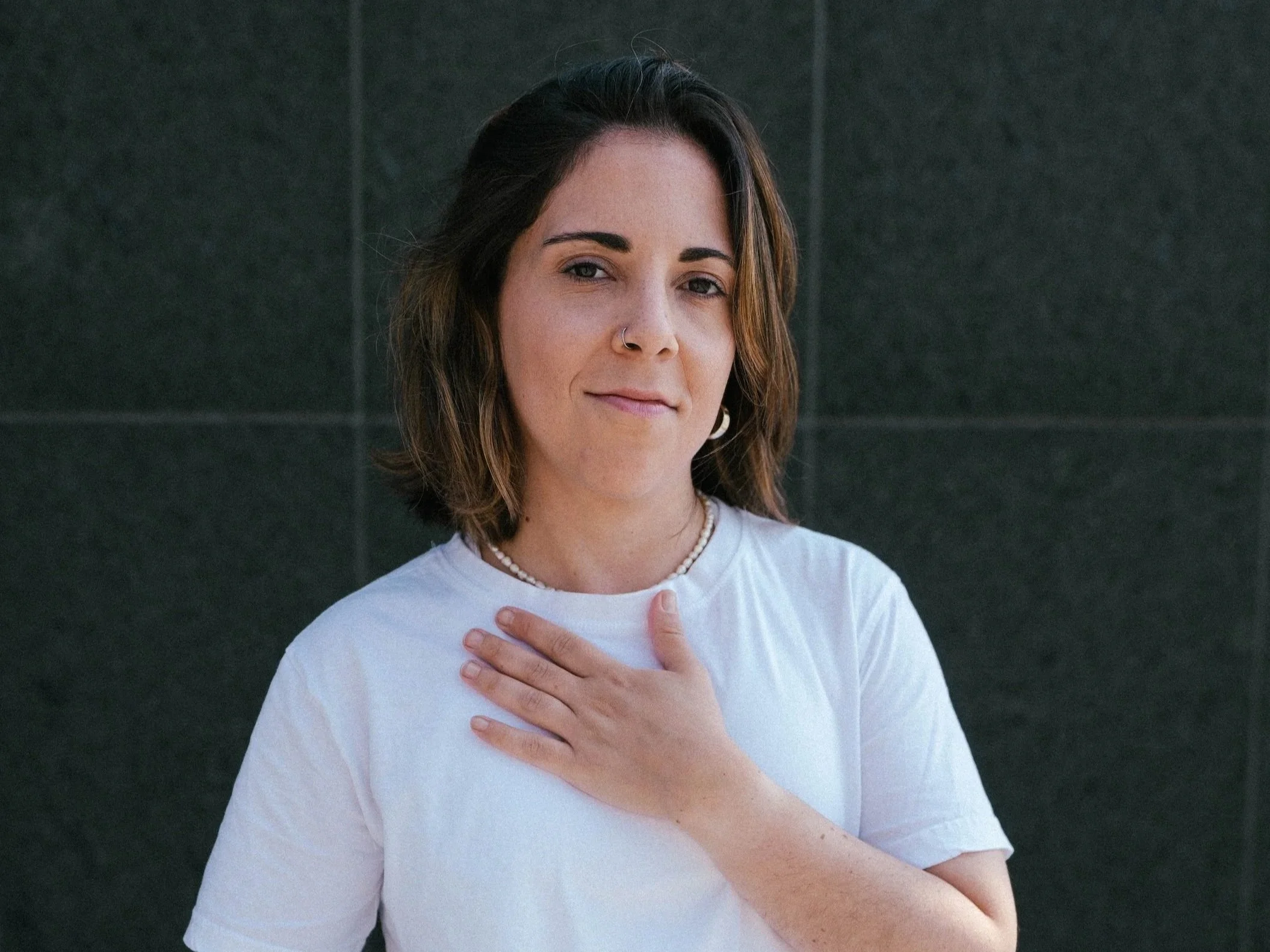 Woman practicing mindful self-compassion with hands on heart — MBCL mindfulness-based compassionate living