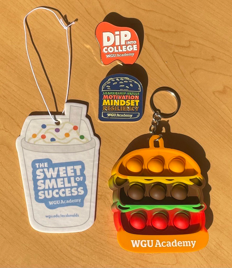 Employee Pin Designs, Vanilla Car Air Fresheners, and Hamburger Pop-it for McDonald's x WGU Academy Partnership Swag