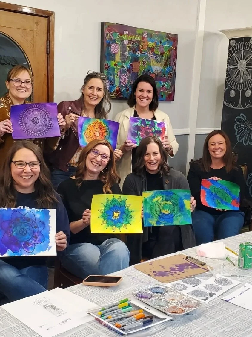 adult women showing their artwork 