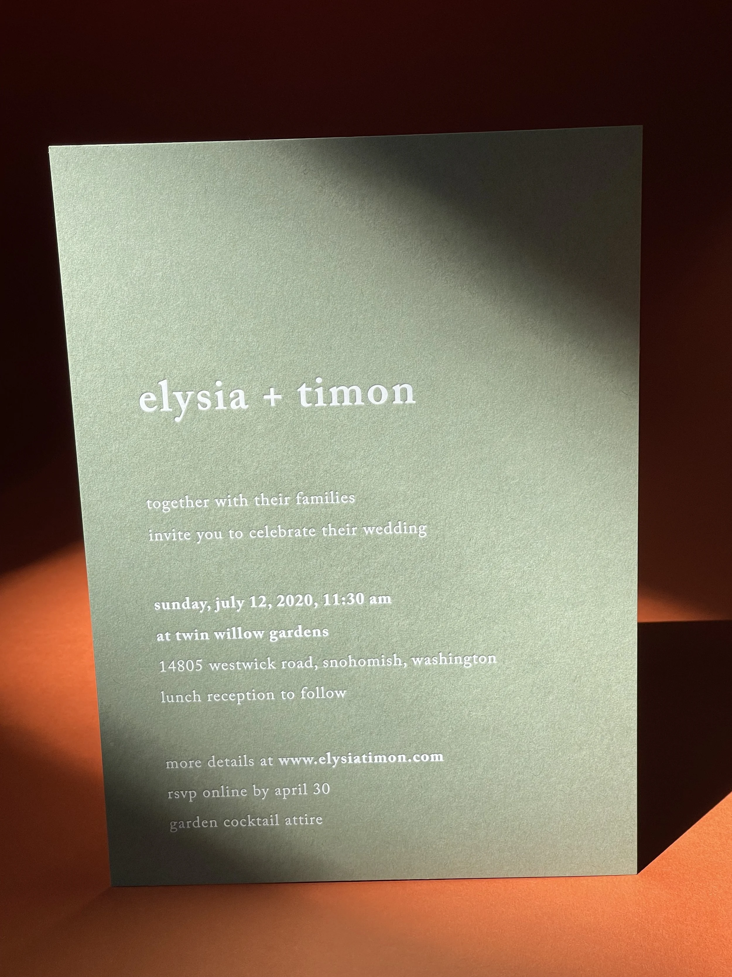 Wedding invitation card with a green background and white text, announcing the marriage of elysia and timon, including date, time, location, and RSVP details.