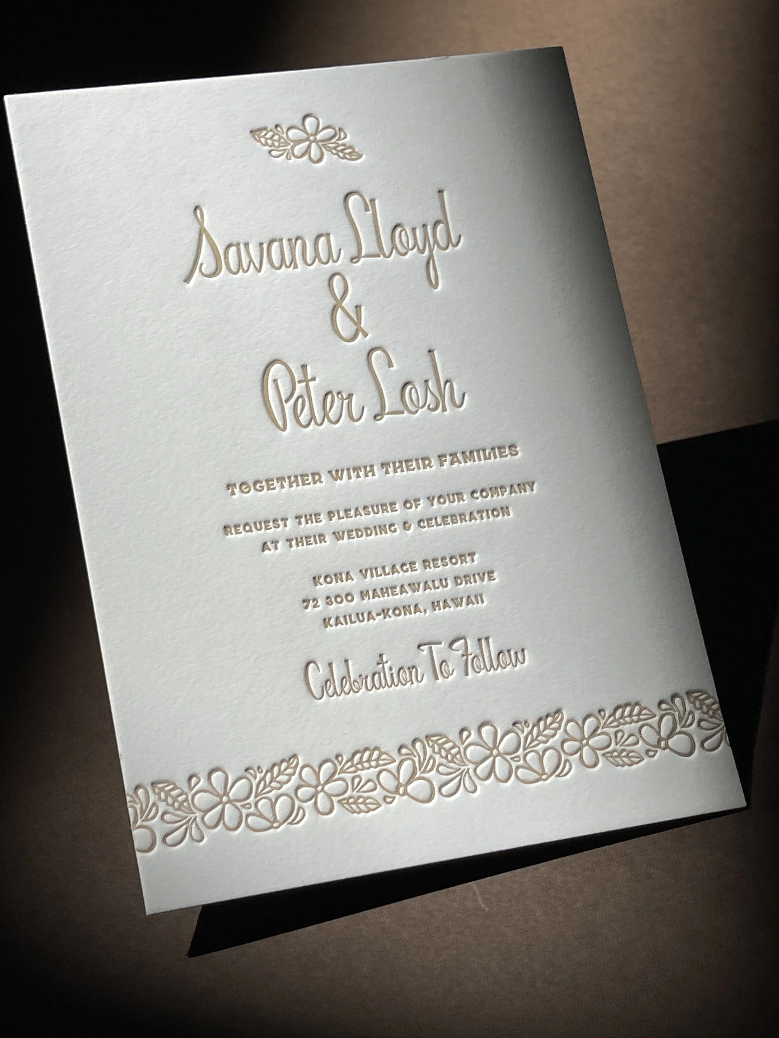 Wedding invitation with floral border and gold embossed text for Savana Lloyd and Peter Losh, inviting guests to their wedding at Kona Village Resort in Hawaii.