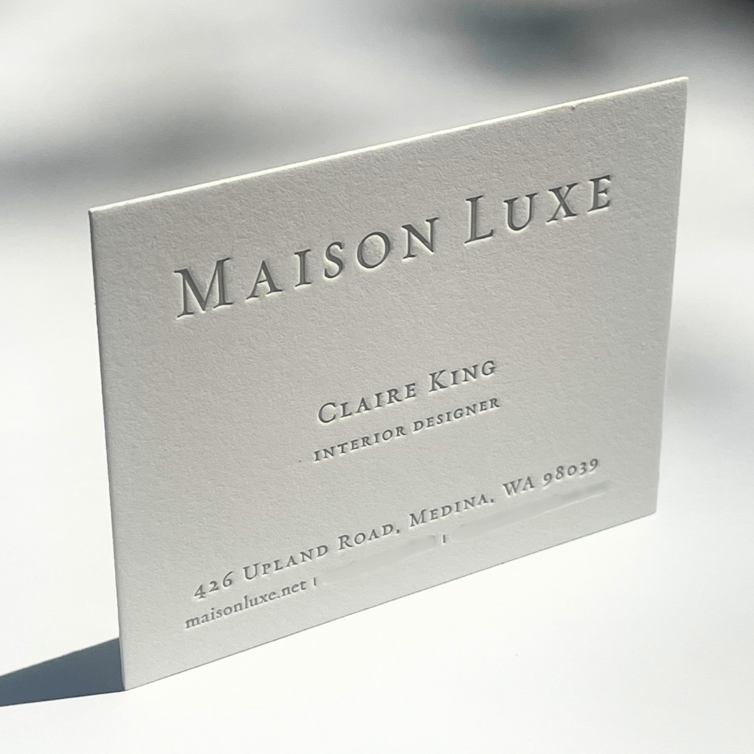 White business card for Maison Luxe with black embossed text, displaying the name Claire King, interior designer, and contact details.