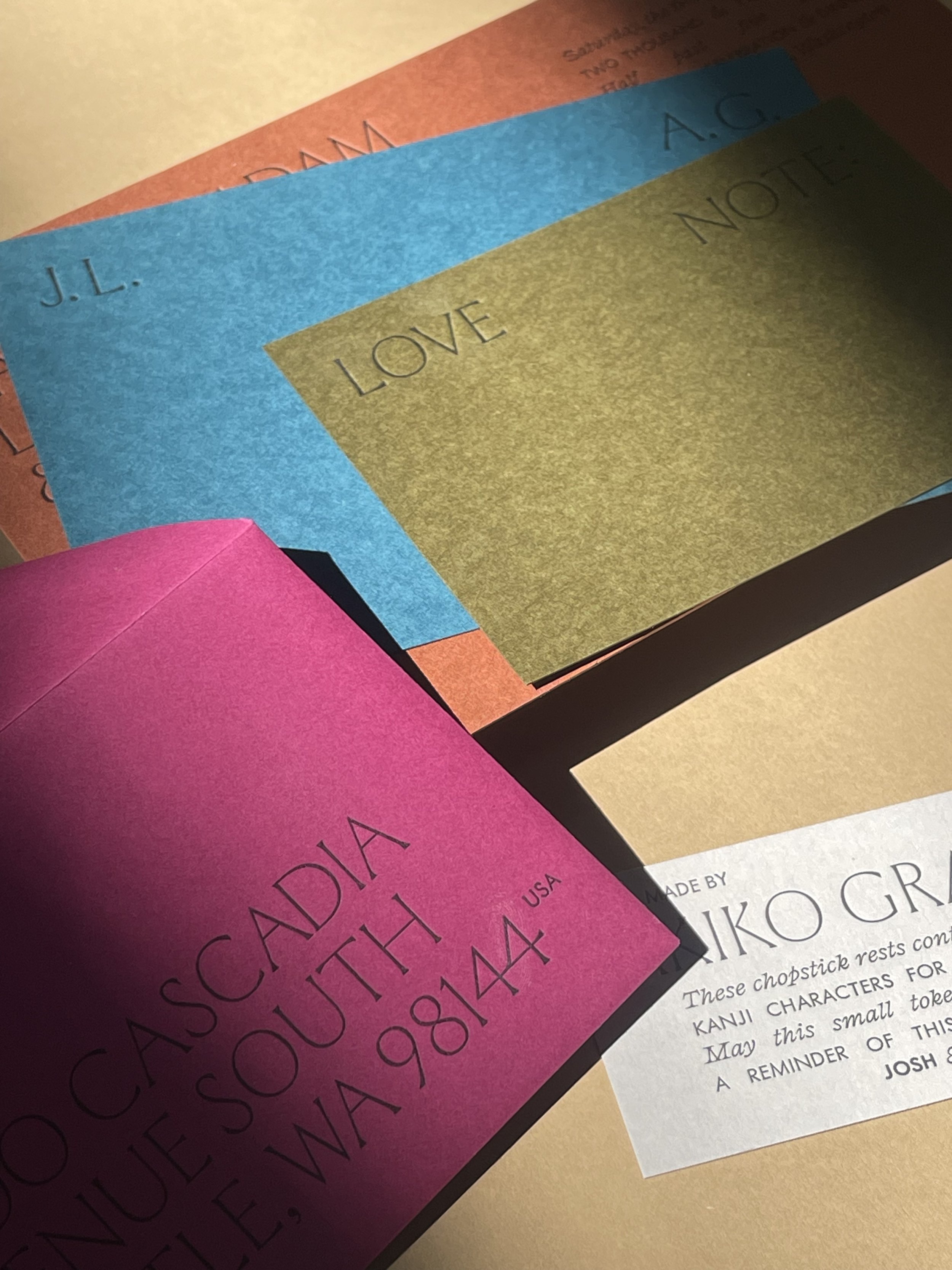 Colorful paper sheets with handwritten words, including 'LOVE' and 'NOTES', overlapping each other.