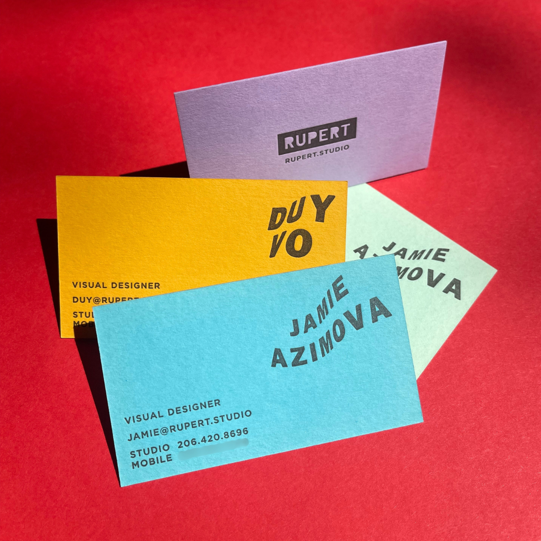Colorful business cards in purple, yellow, blue, and light green on a red background, each displaying a person's name, profession, email, phone number, and studio information.