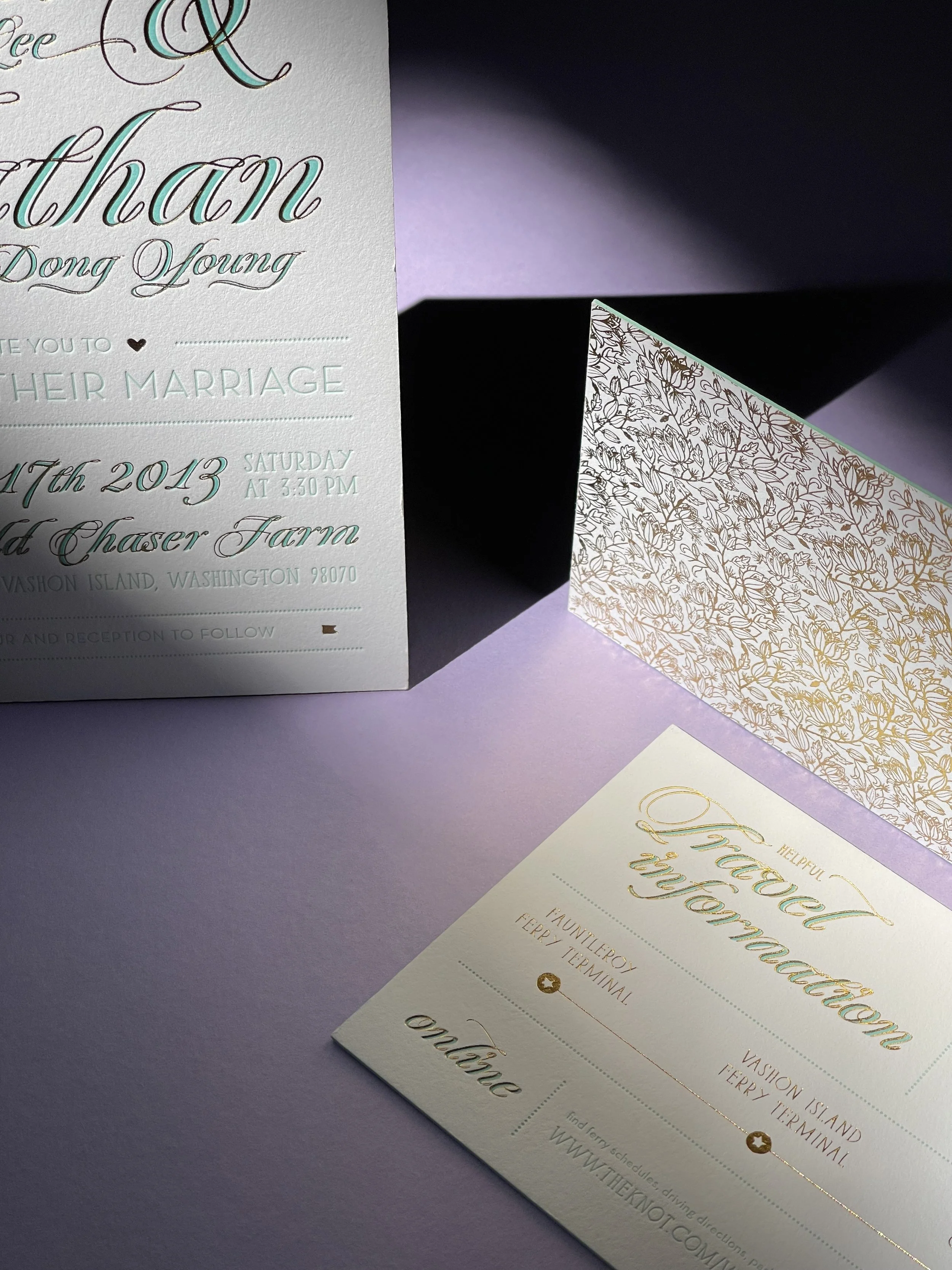 An elegant wedding invitation suite with floral and calligraphy details, including an invitation card, a response card, and a decorative envelope.