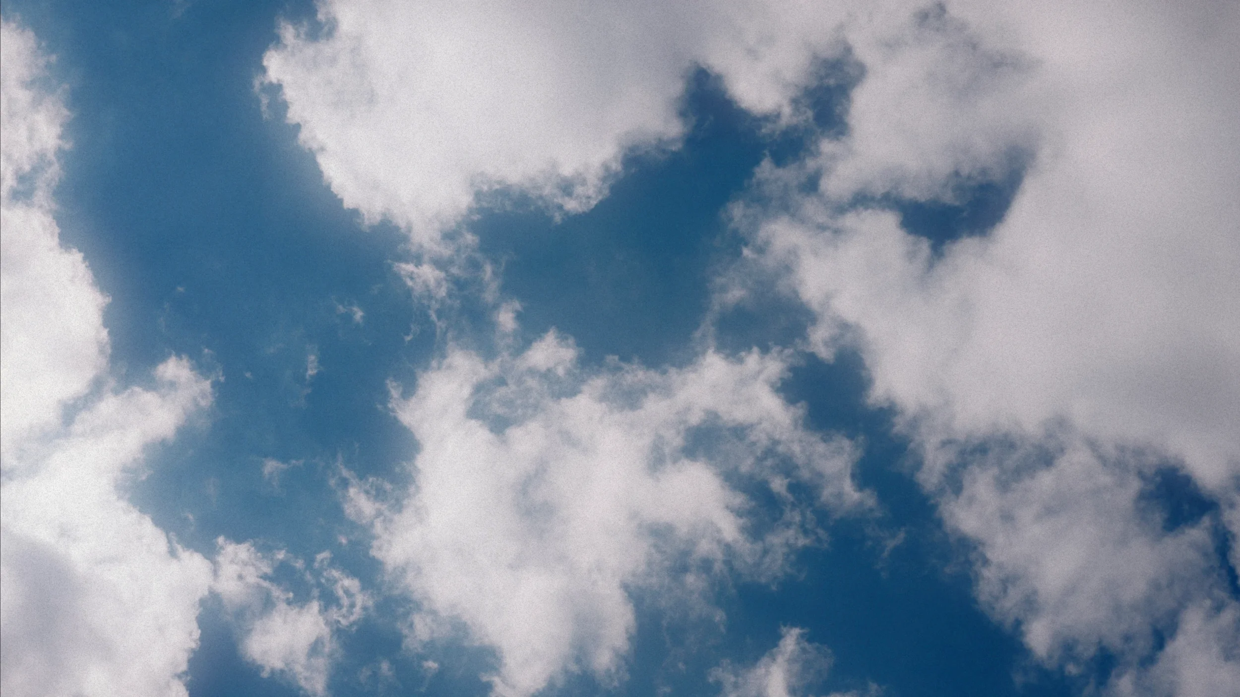 A cloudy sky with varying shades of blue and gray clouds.