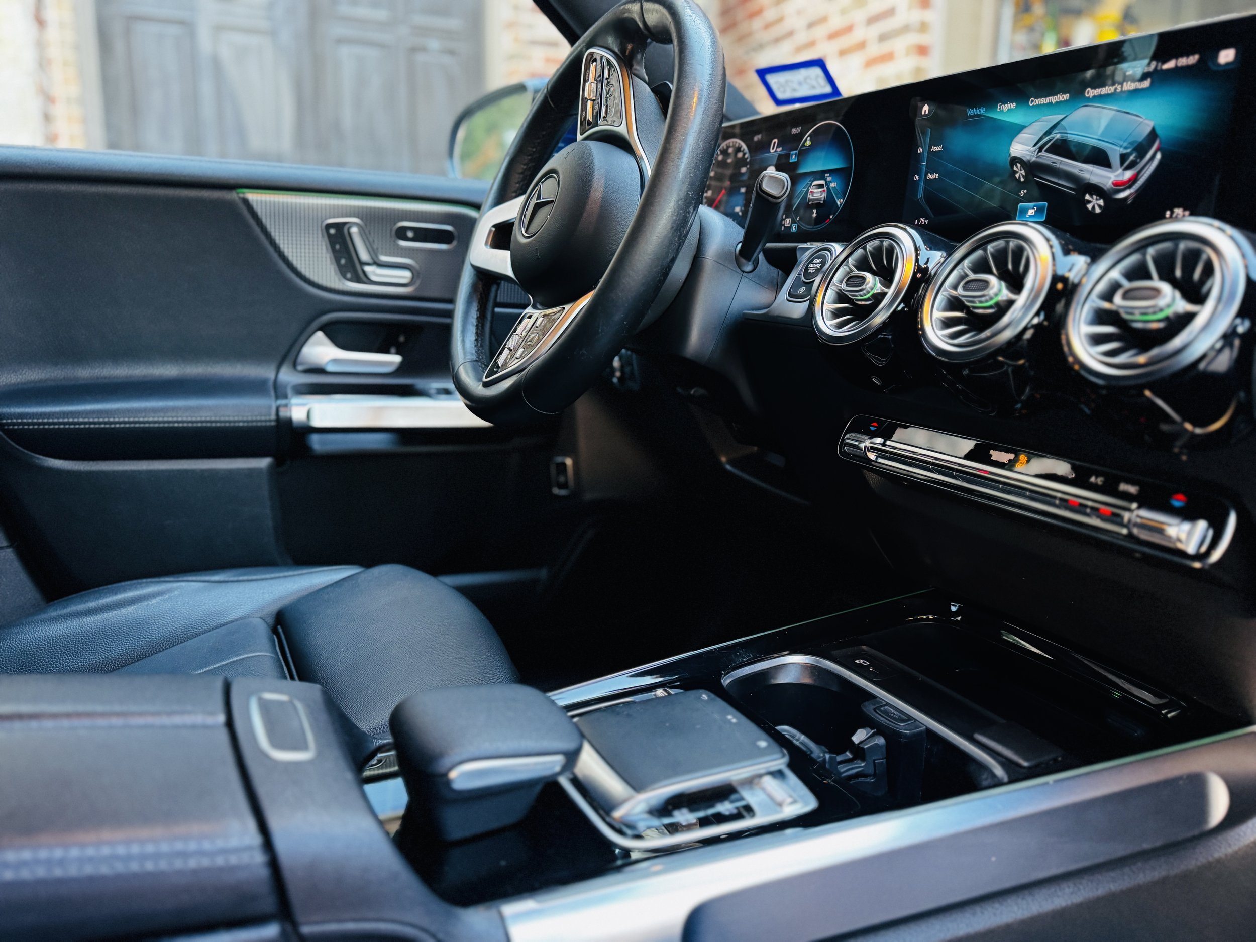 Interior of a modern car with a digital dashboard, steering wheel, air vents, and center console.