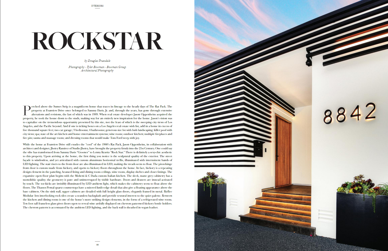 Magazine spread with article titled 'ROCKSTAR' and a photo of the exterior entrance of a modern house with black horizontal siding, wooden stairs, and large house number '8842' at sunset.