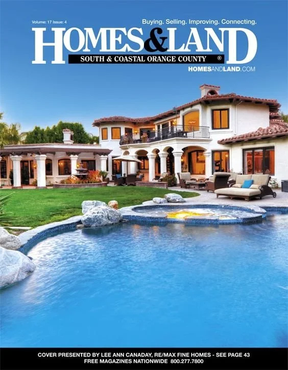 Cover of Homes & Land magazine featuring a luxurious house with a swimming pool in the backyard.