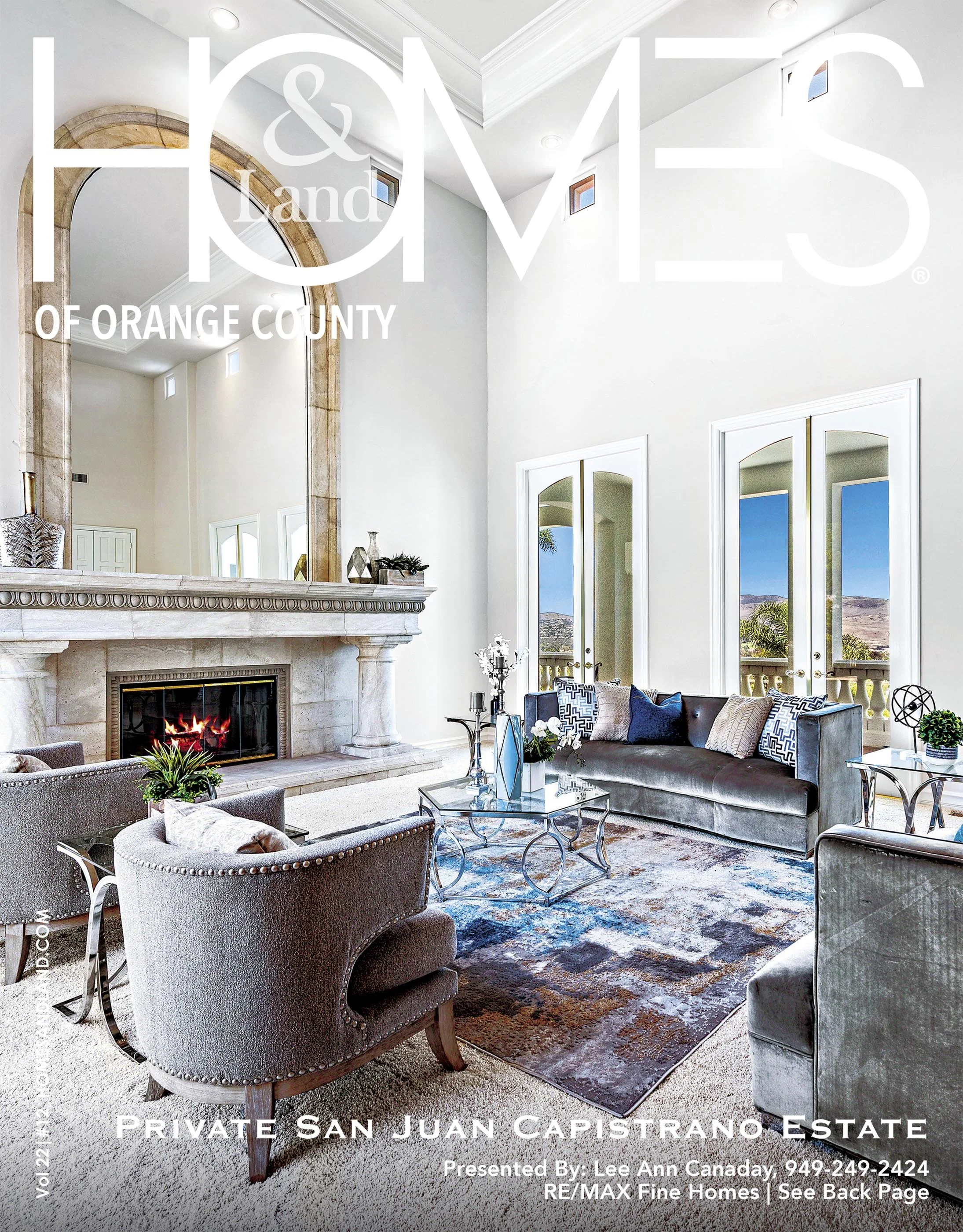 Living room with white walls, high ceiling, large mirror above fireplace, modern furniture, and a view of mountains outside through glass doors