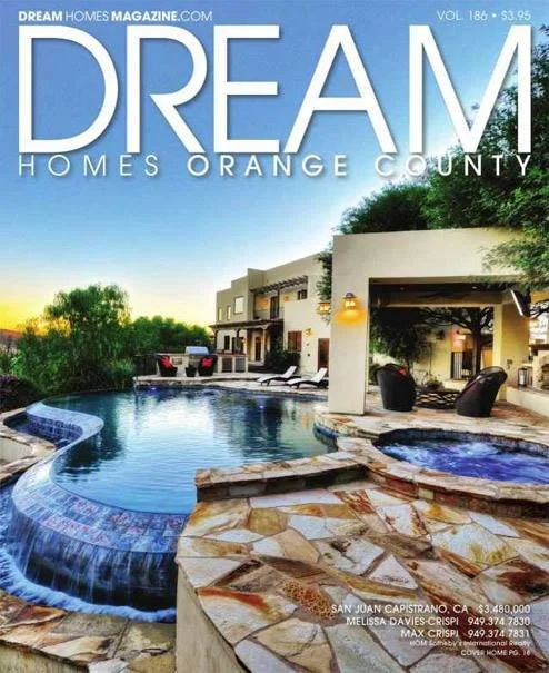 Luxury modern house with a swimming pool and hot tub, outdoor seating area, and lush greenery, on the cover of Dream Homes Magazine.