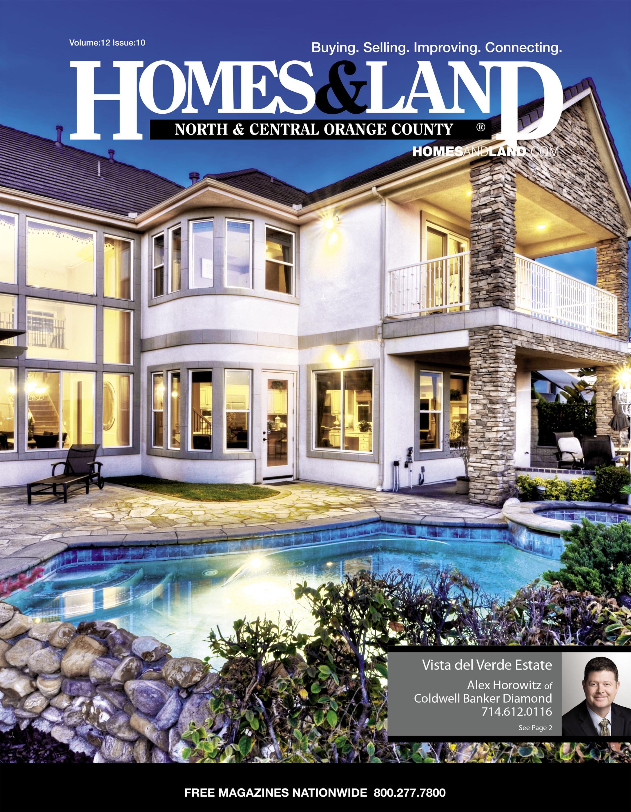 Cover of Homes & Land magazine featuring a large modern house with a swimming pool in the backyard. The house has multiple windows, a small deck, and stone columns, with lights on illuminating the exterior. The magazine title is at the top, and there