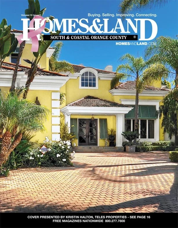 A yellow house with a tiled roof surrounded by palm trees and tropical plants, featuring a brick driveway and front entrance with glass doors, on the cover of Homes & Land magazine.